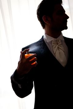 a man in a tuxedo holding an orange lighter