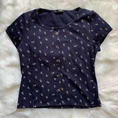 Adorable Tiny Floral Print Short Sleeve Tee! Cute Button Design (The Buttons Are Fake, Just For Looks) Dark Blue (Navy) Size Medium, But Would Best Fit A Small In My Opinion Nwot Not Brandy Melville - Tagged For Exposure Bundle Items For A Killer Discount Fitted Spring T-shirt With Button Closure, Navy Casual Button-up Tops, Blue Buttoned T-shirt For Summer, Navy Short Sleeve Tops With Button Closure, Navy Cotton Tops With Button Closure, Blue T-shirt With Button Closure And Crew Neck, Navy Casual Tops With Button Closure, Casual Navy Tops With Button Closure, Fitted Navy T-shirt For Spring