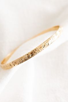 14k gold filled floral patterned bangle If you would like a different length that is not listed, please contact us for a custom order! Please note that there may be slight color variations or a seam where the joints of the bangle has been soldered. Since this piece is handmade, keep in mind that solder marks are visible and is totally normal. Finding Your Size We recommend using a flexible measuring tape to wrap around your hand/knuckles to find the length of your preferred fit. An alternative t Dainty Adjustable 14k Gold Bangle, Adjustable Dainty 14k Gold Bangle, Adjustable Etched 14k Gold Jewelry, Adjustable 14k Gold Etched Jewelry, 14k Gold Etched Bangle Bracelet, Dainty Engraved Bangle Jewelry, Handmade 14k Gold Dainty Bracelet, Handmade Dainty 14k Gold Bracelet, Dainty Handmade Gold Bangle Bracelet