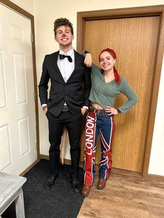 a man and woman in tuxedos standing next to each other near a door