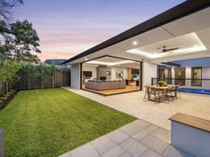 an outdoor living room and dining area with grass