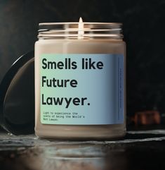 a candle sitting on top of a table next to a jar with the words smells like future