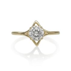 a yellow gold ring with a white diamond in the center, on a white background