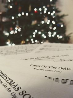 sheet music with christmas tree in the background