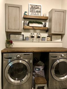 a washer and dryer in a small room with shelves above them that hold items