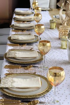 the table is set with white and gold plates