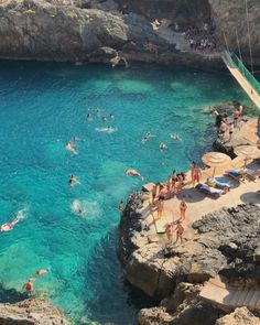 people are swimming in the clear blue water