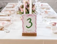 the table is set with place cards and candles