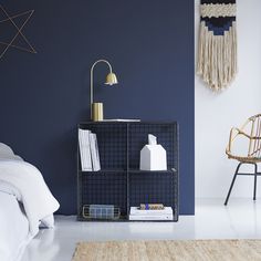 a bedroom with blue walls and white bedding