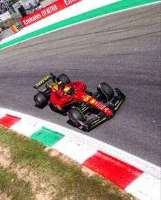 a man driving a red race car on a track