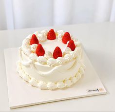 a cake with white frosting and strawberries on top