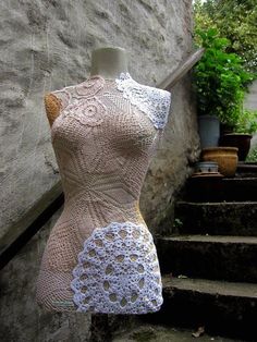 a dress made out of crochet is on display in front of some stairs