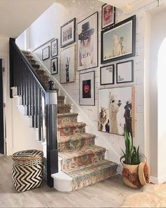 a staircase with pictures on the wall above it