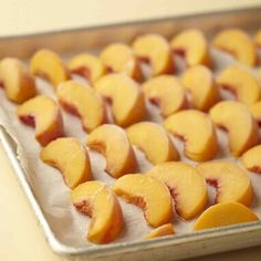 sliced peaches on a baking sheet ready to be baked in the oven for dessert