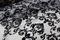 black and white lace fabric with floral design on the bottom, as seen from above