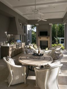 an outdoor living room with white wicker furniture