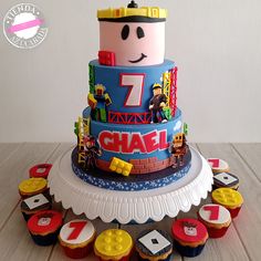 a birthday cake with cupcakes on the bottom and an image of a character on top