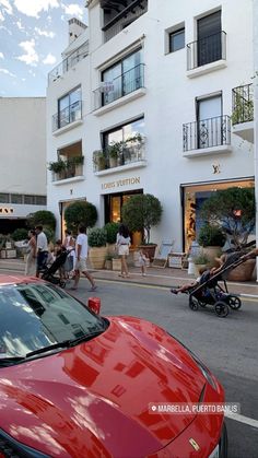 people walking down the street in front of a building