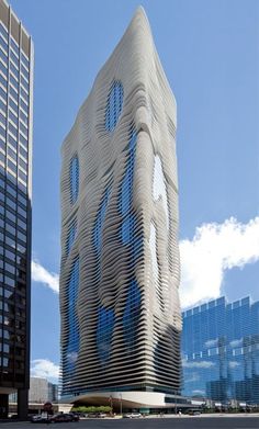 a tall building with many windows next to other buildings