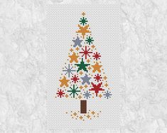 a cross stitch christmas tree with stars on it