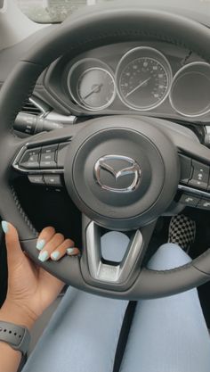 a woman is sitting behind the wheel of a car with her hands on the steering wheel