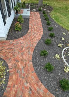 a brick walkway in front of a white house