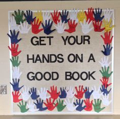 a sign that says get your hands on a good book with handprints all over it