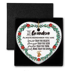 a heart shaped ornament with the words to my grandson on it in a gift box