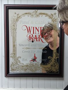 a woman looking at a wine bar sign