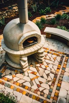 an outdoor pizza oven is shown in the middle of a stone patio with benches around it