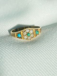 Antique Georgian (1823) 15ct gold turquoise ring SIZE N1/2 A fantastic antique piece, fully hallmarked 15 625, assayed in Birmingham and makers mark. Central turquoise stone of 1.5mm surrounded by 6 x 2mm seed pearls.  2 x turquoise stones on shoulders of 2mm Ring measures 7mm some discolouration to the central and right stones due to age comes in vintage box Antique Turquoise Ring In Yellow Gold, Antique Yellow Gold Turquoise Cabochon Ring, Vintage Yellow Gold Turquoise Ring Hallmarked, Antique Yellow Gold Turquoise Ring For Anniversary, Heirloom Hallmarked Yellow Gold Turquoise Ring, Antique Turquoise Anniversary Ring, Antique Hallmarked Turquoise Ring, Antique Turquoise Round Ring For Wedding, Antique Turquoise Ring For Wedding