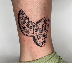 a black and white tattoo on the leg of a person with a bow tie around it