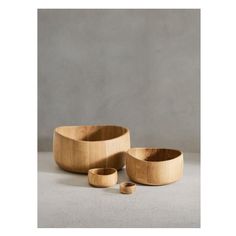 three wooden bowls sitting on top of a gray floor next to each other and one is empty