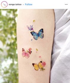 three butterflies on the left arm and one is blue, yellow, pink and white