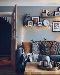 a living room filled with lots of furniture and pictures on the wall above it's coffee table