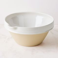 a white and yellow bowl sitting on top of a table