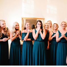 a group of women standing next to each other in front of a mirror with their hands together