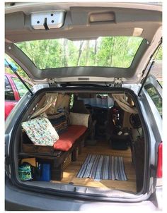 the back end of a car with its trunk open and two seats folded up in it