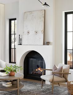 a living room filled with furniture and a fire place in front of a large window