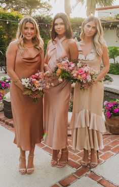 three bridesmaids pose for the camera with their bouquets