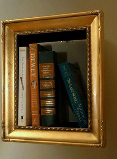 there is a gold frame with books on it