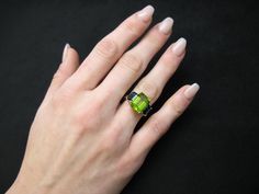 A beautiful pairing of bright colors and sleek shapes form this modern version of a classic 3-stone ring. This stylish ring features a gorgeous, 5.12 carat emerald-cut peridot flanked on either side by emerald-cut rich blue sapphires. The peridot has been set in yellow gold to highlight its warm color, while the blue sapphires have been set in striking white gold, creating a lovely, eye-catching contrast. So pretty and wearable! Handcrafted in 18k white and yellow gold by our Master Jewelers in Modern Green Jewelry With Accent Stones, Modern Green Emerald Ring With Accent Stones, Modern Peridot Jewelry For Formal Occasions, Modern Green Emerald-cut Jewelry, Emerald Cut Peridot Jewelry For Formal Events, Emerald Cut Peridot Jewelry For Formal Occasions, Formal Emerald Cut Peridot Jewelry, Modern Green Emerald Cut Ring, Modern Green Peridot Jewelry