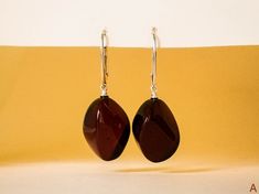 "Natural Baltic dar red amber earrings - the best gift for your loved one. These genuine handmade amber earrings are modern and classy at the same time and you can definitely sense the quality. MATERIALS AND SIZE: Stone: 100% Natural Baltic Amber Findings: Sterling silver 925 Earrings A Weight: 5 g (0,17 oz) Bead size: 2 cm (0,78 in) x 1,6 cm (0,62 in) Total earring length: 4,1 cm (1,61 in) Earrings B Weight: 6,1 g (0,21 oz) Bead size: 2,3 cm (0,90 in) x 1,8 cm (0,70 in) Total earring length: 4, Golden Logo, Christmas Gifts For Wife, Amber Earrings, Natural Amber, Round Stud Earrings, Amber Jewelry, Gift For Wife, Golden Color, Baltic Amber