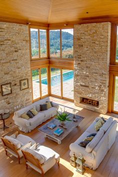 a living room filled with furniture next to a large window covered in wood and stone