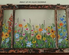 an old window with flowers painted on it