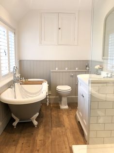 a bathroom with a claw foot tub, toilet and sink next to a walk in shower