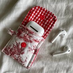 an apple airpods case sitting on top of a bed