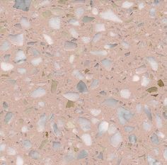 a close up view of a pink surface with white and grey pebbles on it,