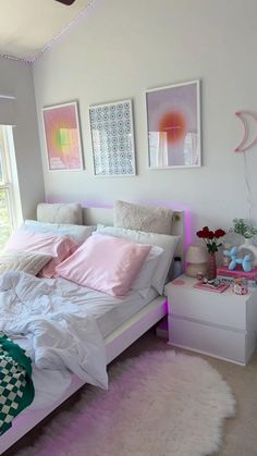 a white bed with pink pillows and blankets