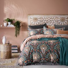 a bedroom with pink walls and an ornate headboard on the wall, decorated with plants